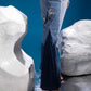 Close-up of Fearless Ferð Denim Jumpsuit showing one-shoulder silhouette, bell sleeve, flared leg and Ferð patchwork