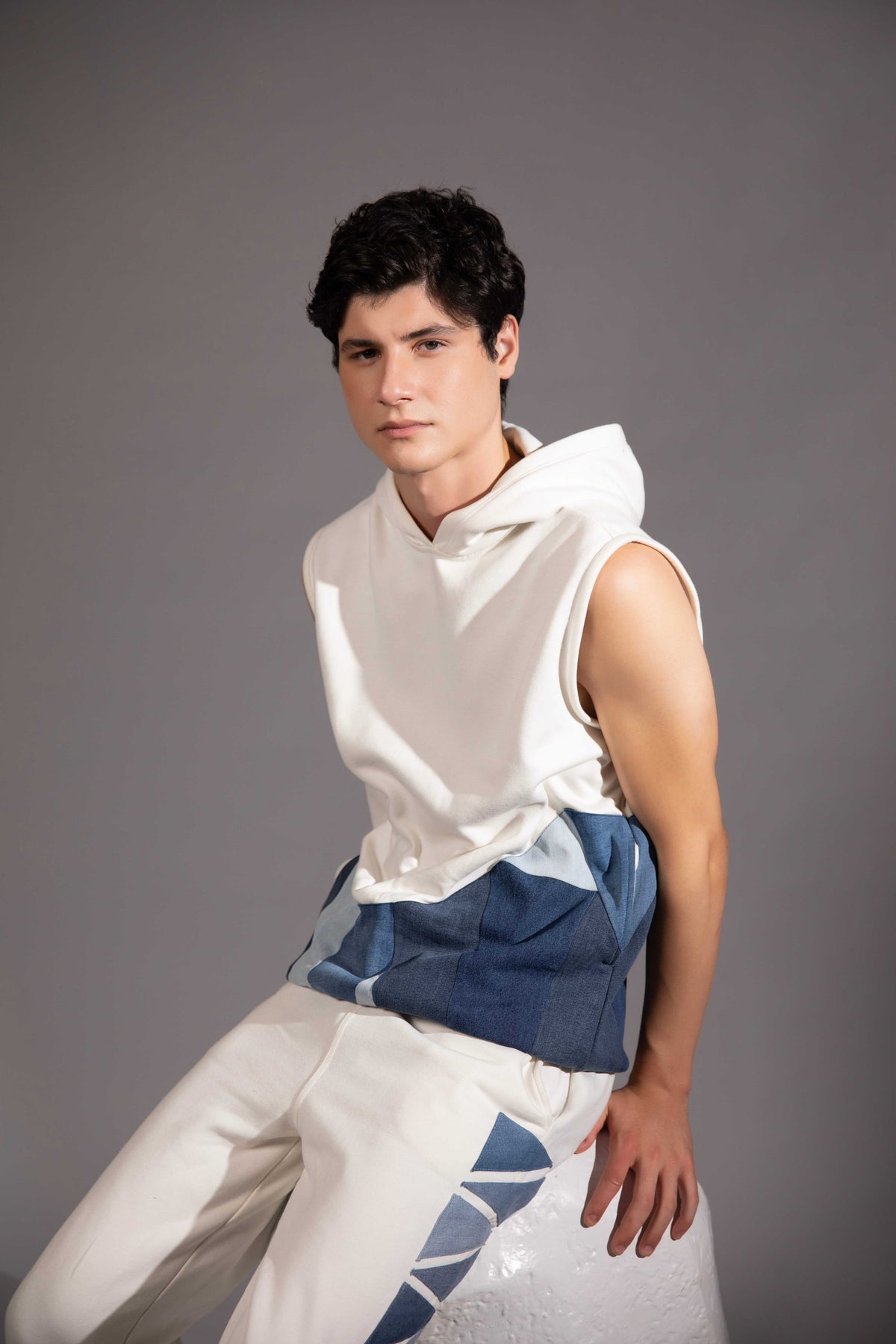 Layered Sleeveless Hoodie showing layered blue denim textures and geometric forms