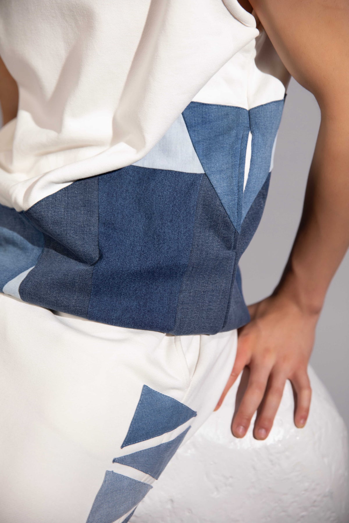 Close-up of Layered Sleeveless Hoodie showing glacier-inspired denim patchwork