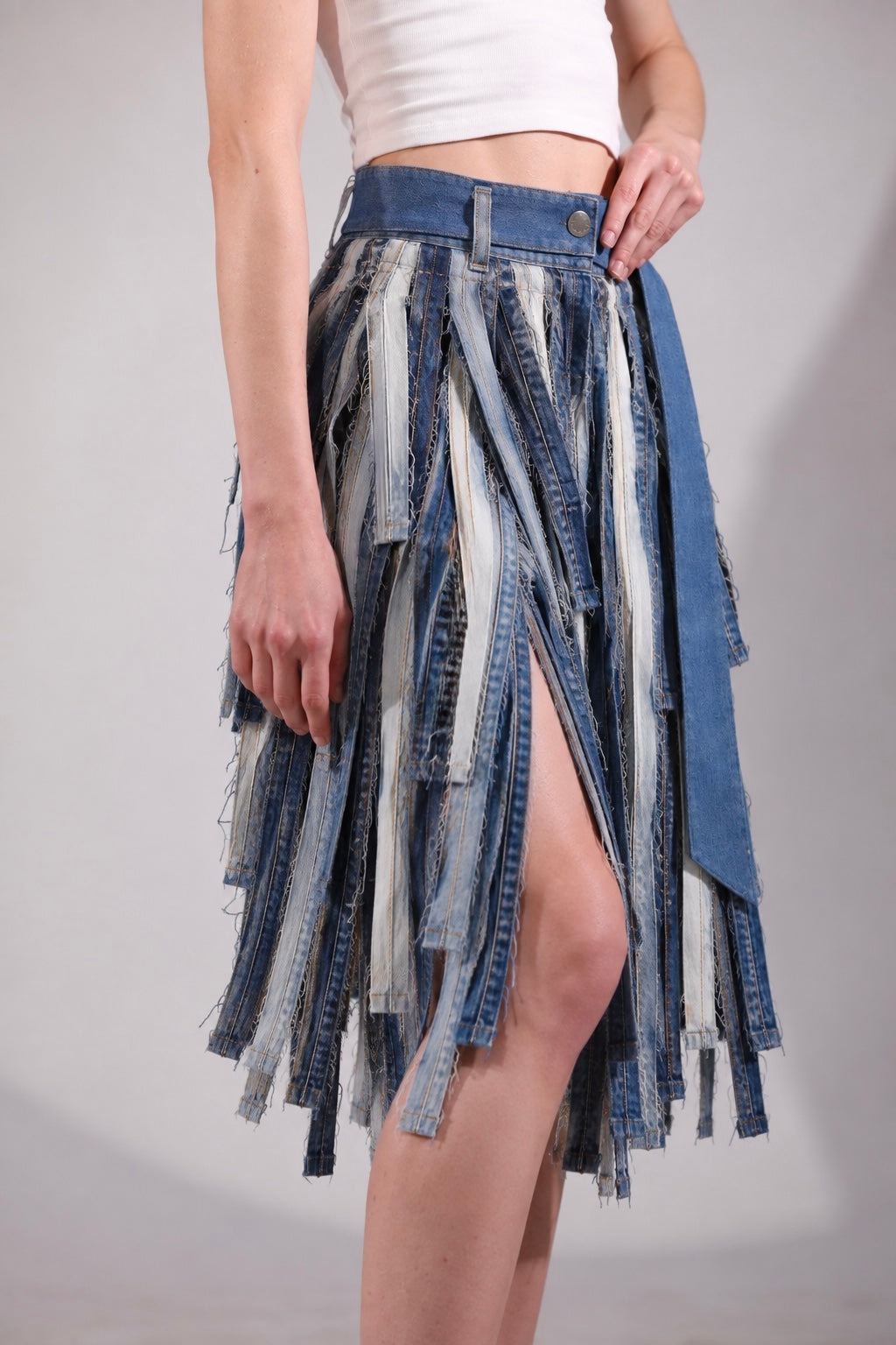 Close-up of The Meltwater Skirt showing deconstructed denim stripwork and frayed edges